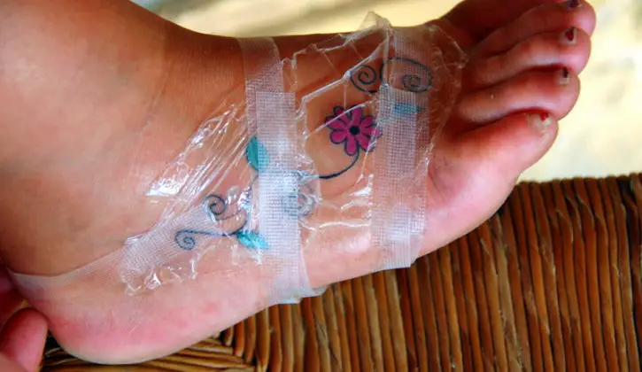 A foot tattoo takes longer to heal than other tattoos. Here, the foot is still wrapped after it was inked.